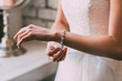 Bride fastens a bracelet. Wedding concept. Artwork. Soft focus on a hand