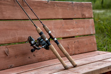 Two Fishing Poles On A Bench