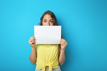 Young Woman With Blank Paper On Blue Background