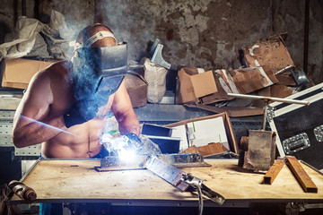 man welding a metal with arc welding machine