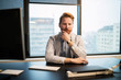 © NDABCREATIVITY - Portrait of young businessman sitting at desk