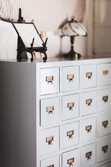 Wooden vintage cupboard with a lot of repeated small bronze lockers. Frame and lamp no top