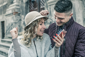 Happy couple outdoor. Happy couple listening music on the phone.  Couple dancing on the street.