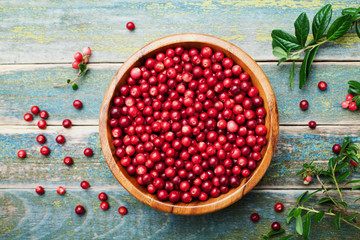 Wall Mural - Ripe fresh cowberry (lingonberry, partridgeberry, foxberry) in wooden bowl on rustic vintage table from above.