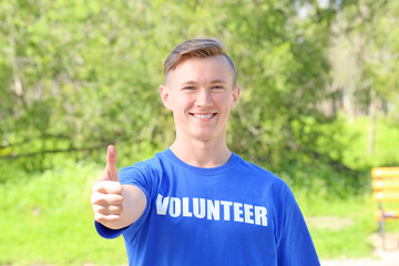 Canvas Print - Young handsome boy standing outdoors. Volunteering concept