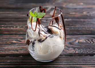 Wall Mural - Delicious dessert with chocolate sauce in glass on wooden table