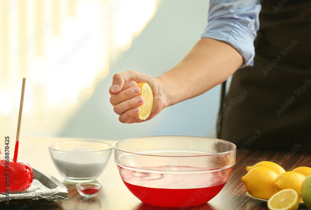 Young woman preparing toffee apples in kitchen
