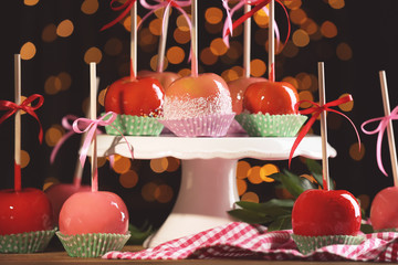 Sticker - Ceramic stand with delicious candy apples on blurred background