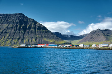 Wall Mural - Travel to Iceland. beautiful sunrise over the ocean and fjord in Iceland. Icelandic landscape with mountains, sky and clouds. View of Flateyri, a village in the north-west of Iceland, on the