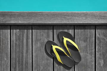 Wall Mural - Flip-flops on wooden pontoon at sea resort. Summer vacation concept