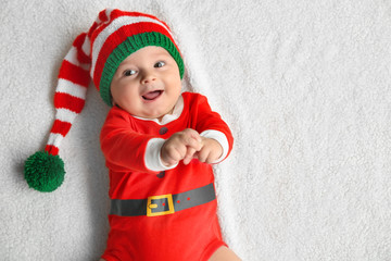 Wall Mural - Cute little baby in Santa costume lying on soft fabric