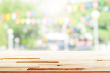 Empty wooden table with party in garden background blurred.