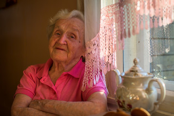 Wall Mural - Older woman relaxed sitting at the tea table.