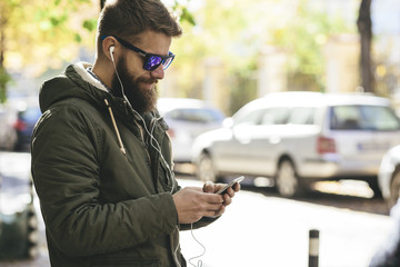 Young man using his smartphone, outdoors