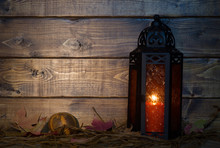 Glowing Orange Lantern On A Rustic Wooden Background