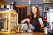 Lovely girl barista folds gingerbread in a package in a coffee house