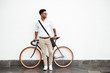 © Drobot Dean - Man standing over white wall outdoors looking aside.