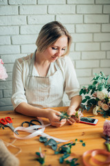 Wall Mural - Small business. Male florist unfocused in flower shop. Floral design studio, making decorations and arrangements