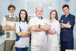 © spaskov - Group of dentists standing in their office and looking at camera.