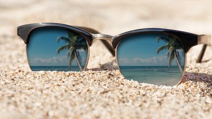 Wall Mural - Cinemagraph - Sunglasses on the sand. Motion Photo.