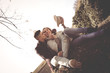 © liderina - Happy couple sitting on the hill and enjoying in beautiful day. Young couple having fun on the grass.