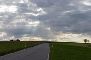 road on august summer evening with contrastful cloudy sky