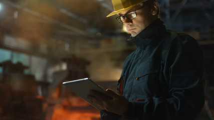 Engineer in Glasses using Tablet PC in Foundry. Industrial Environment.