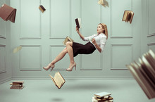 A Relaxed Woman Levitates In A Room Full Of Flying Books