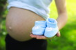 Brzuch kobiety w ciąży z bucikami