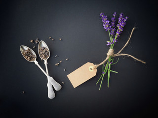 Fresh and dry lavender on black background. Two spoons and cord,