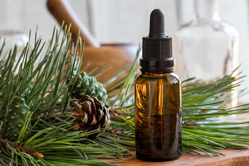 Wall Mural - A bottle of pine essential oil with pine twigs