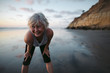 © Rob and Julia Campbell/Stocksy - Vibrant mature woman enjoying herself on the beach at sunset