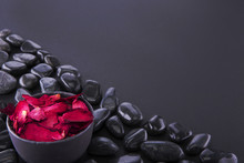 Spa. Petals Of A Red Rose In A Black Vase, Black Pebbles. Copy Spice. Toned