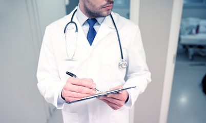 Wall Mural - close up of doctor with clipboard at hospital