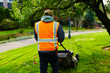 man mowing a lawn in the morning with leaves