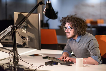 Wall Mural - man working on computer in dark startup office