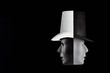 © Greg Brave - Black and white masks wearing top hat looking in opposite directions isolated on black background with copy space. Double talk and hypocricy concept