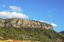  Green Trees And Rock Cliffs Against Blue Cloudy Sky
