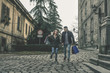 © liderina - Couple in shopping together. Young couple holding hands and running trough street.