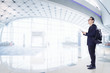 © jamesteohart - Young business man using digital pad smiling happy inside  airport waiting hall  .