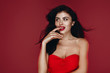 © PinkCoffee Studio - Beauty Brunette Woman with Perfect Makeup in red dress. Beautiful Professional Holiday Make up. Beauty Girl  Face  studio portrait isolated on red background