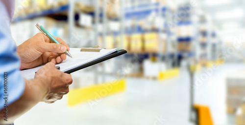 Cuadros en Lienzo logistics service man writing documents on clipboard in warehouse
