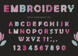 Embroidery font design. Cute ABC letters and numbers in pastel colors on the black background.
