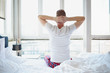 © nenadaksic - Man stretching in bed, back view
