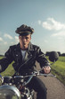© ysbrandcosijn - Vintage motorcyclist riding on country road in summer.