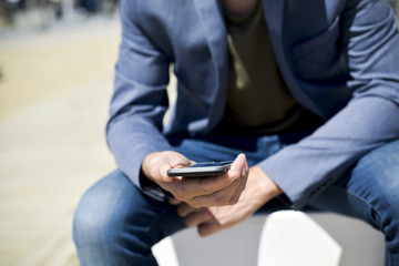 Wall Mural - man using a smartphone next to the beach