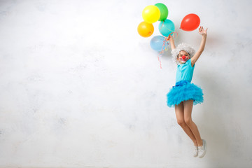 Little girl wearing clown costume isolated on white