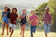 © Monkey Business - Six pre-teen friends running in a park, front view, close up