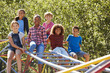 © Monkey Business - Pre-teen friends sitting on climbing frame in playground