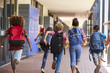 © Monkey Business - School kids running in elementary school hallway, back view